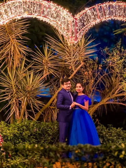 The large, illuminated heart prop provides a grand and romantic frame for this couple's night-time portrait.
