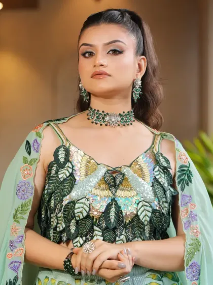 This close-up shows the detailed sequin and thread work on the blouse of the pastel green lehenga. The matching choker set completes this elegant ensemble.
