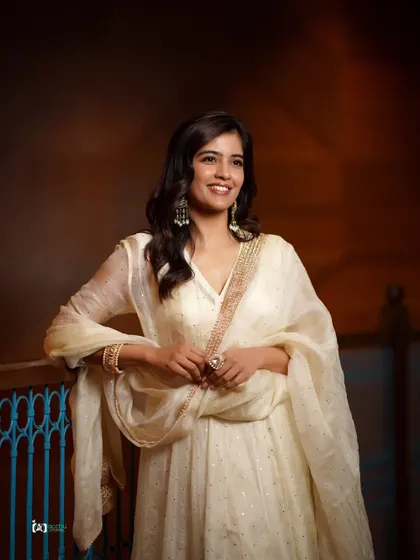 A classic portrait pose that is both elegant and approachable. The soft lighting and warm background create a timeless feel.