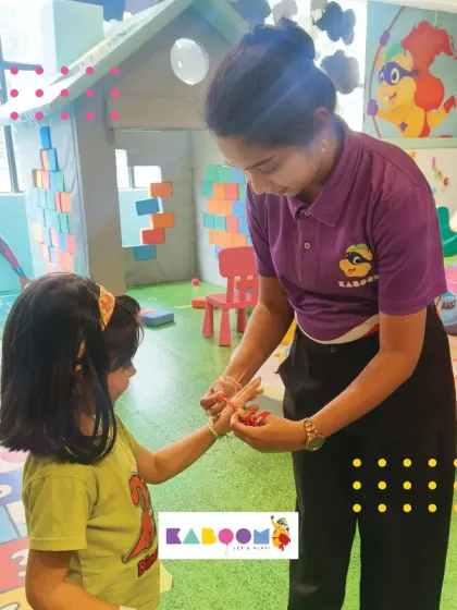 A moment of connection as a staff member helps a child with her friendship band. We foster a friendly and caring atmosphere in all our activities.