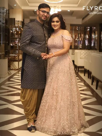 This couple is the definition of elegance. Her blush pink off-shoulder gown and his patterned Indo-western sherwani are a perfect match for a reception or engagement party.