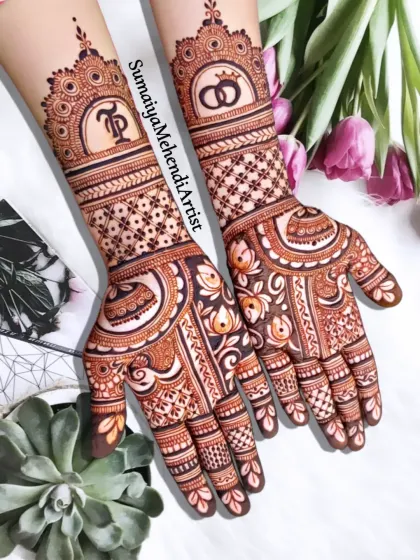 Perfect for an engagement or for the bride who wants a more minimal look. This semi bridal design features the couple's initials and wedding rings, blending personal symbols with elegant patterns that extend to the mid-forearm.
