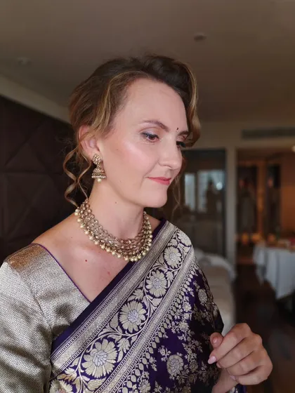 A side profile of this wedding guest's look. The soft, romantic updo and the glowing skin are perfect for an elegant evening event.