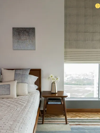 A bedroom with a view. The design prioritizes the connection to the outdoors, with a large window framing the landscape. The use of natural wood and a simple color palette ensures the focus remains on the scenery.