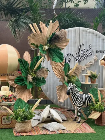 A different take on the "Wild One" theme, this setup includes a hot air balloon prop, vintage-style suitcases, and a zebra statue. The boho-chic style is perfect for a stylish first birthday.