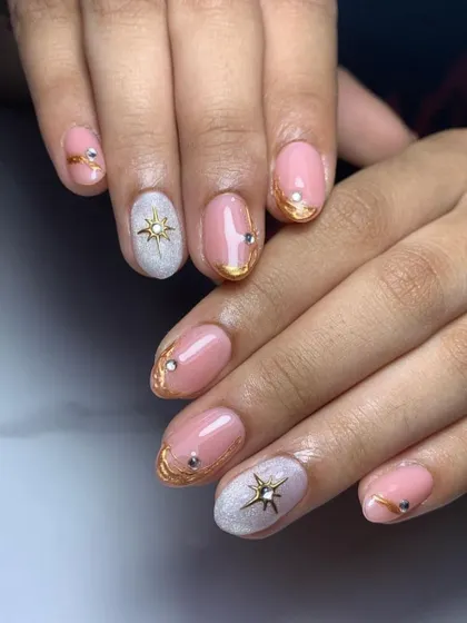 Starry-eyed. A sweet and celestial design with a baby pink base, gold chrome details, and a textured "sugar" glitter nail, all accented with star charms.