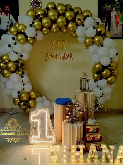 A classic gold and white balloon ring for a first birthday, complete with a light-up number and marquee letters.