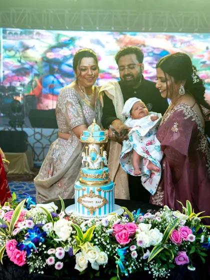 A carousel cake for a baby's one-month milestone. This beautiful blue and gold cake features a rotating carousel with white horses, making it a magical centerpiece for a first celebration.