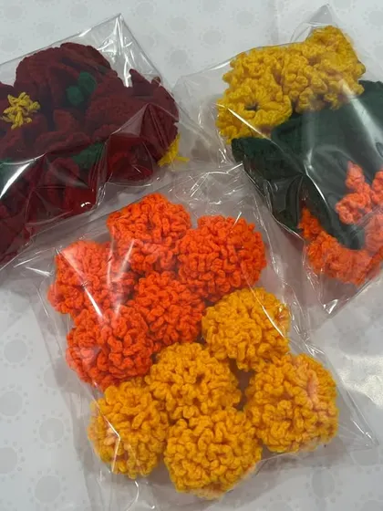 Packets of crochet hibiscus and marigold flowers ready to be used in a wedding 'Rukhwat'. They are a practical and beautiful addition to the traditional bridal trousseau display.