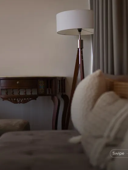 A cozy corner of the living room, with a floor lamp providing soft evening light. The focus is on creating a comfortable and intimate atmosphere for relaxation.