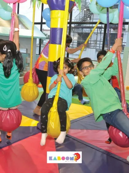 Our play area is always buzzing with energy. Here, a group of kids enjoys the spinning carousel, one of our most popular attractions for cooperative play.