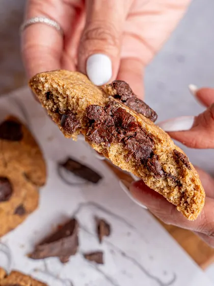 A close-up shot showing the gooey, melted chocolate inside the cookie. This detail-oriented food photography is designed to trigger cravings and drive immediate interest.
