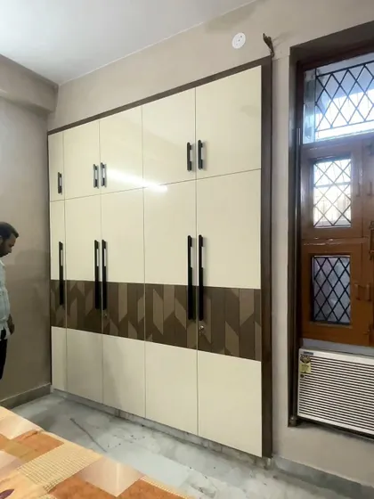 A neutral color palette is always a classic choice. This floor-to-ceiling wardrobe features a dual-tone design with a geometric wooden pattern, adding a modern touch.