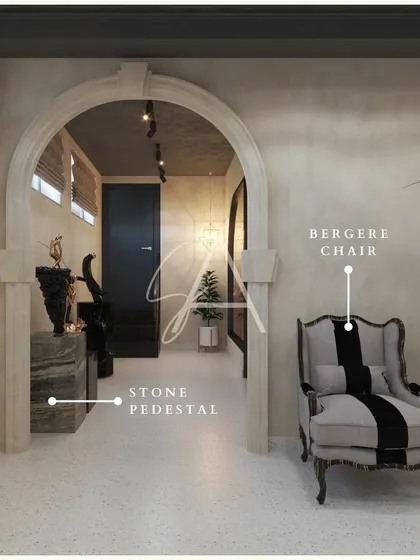 A classic Bergere chair is given a modern twist with bold striped fabric. Placed near a stone pedestal and archway, this display merges classical forms with contemporary style.