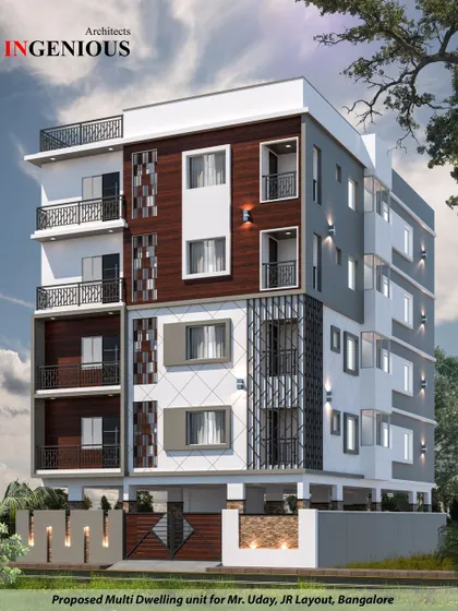 For this multi-dwelling unit in Haralur, the design incorporates decorative geometric screens and varied textures. The facade is a dynamic composition of wood, grey panels, and patterned jalli work.