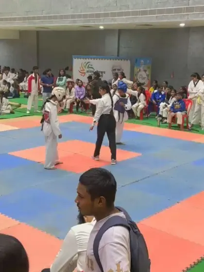 A referee officiates a Taekwondo match between two young female athletes. We support events that provide equal opportunities for both boys and girls to compete and demonstrate their skills.