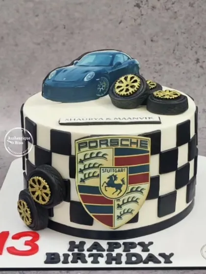 A close-up of our Porsche cake, showing the detailed edible logo and checkered design.