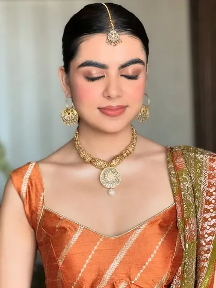 Eyes closed to highlight the soft, earthy tones on the eyelids. This makeup style is perfect for a traditional and elegant Mehendi ceremony.