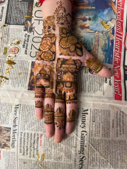 A detailed design on the back of the hand, featuring architectural elements and a small elephant on the fingers.