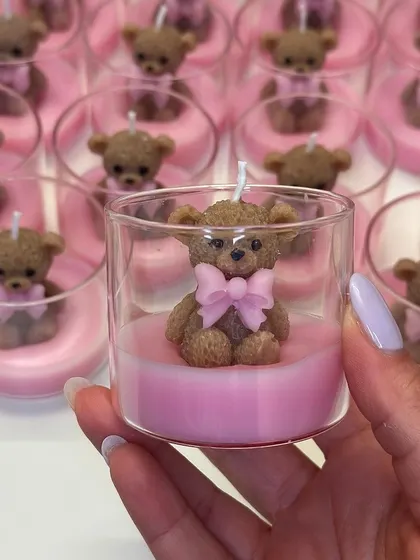 A new addition for baby showers and kids' birthdays: a cute teddy bear with a pink bow, sitting inside a glass candle.