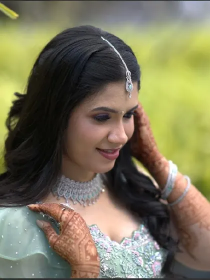 A close-up of her happy expression. The makeup enhances her natural beauty, with a focus on glowing skin and softly defined eyes.