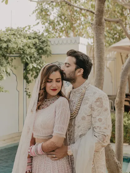 A tender moment between the bride and groom. The soft, natural light and the elegant backdrop of the palace create a romantic and timeless photograph.