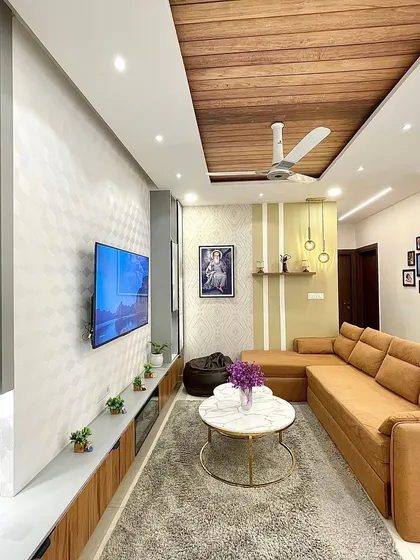 The TV wall in this living room features vertical gray accents with backlighting, creating a subtle yet impactful feature. The floating console keeps the look clean and modern.