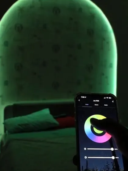A close-up of the app's color wheel being used to change the back-lighting of a custom headboard to a soft green.