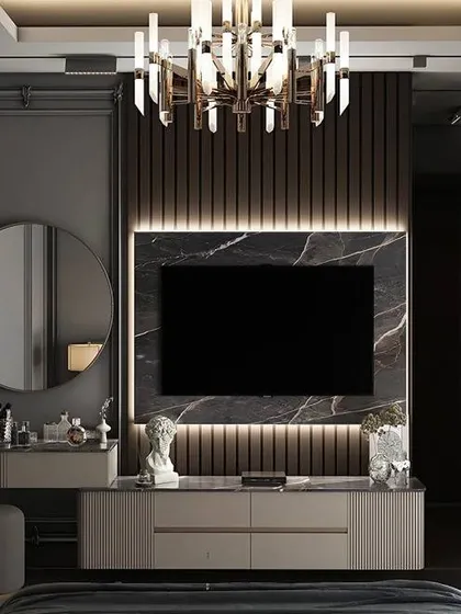This design integrates a TV and a dressing table into a single unit within the bedroom. The dark marble and wood paneling create a moody and sophisticated look.