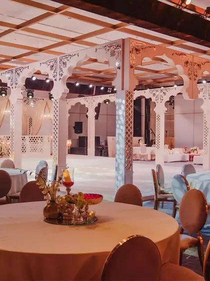 The entire venue bathed in a warm, golden light. This shot captures the scale of the transformation, with the seating arrangements and the grand stage creating a cohesive, luxurious environment.