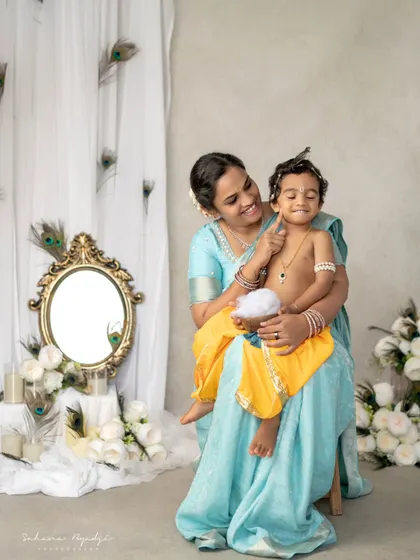 A playful moment between mother and son during their Krishna-themed shoot. Her loving gaze and his happy expression are what make these sessions so special.