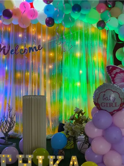 A beautiful pastel-themed welcome celebration for baby Kathika. The decor includes butterfly accents, a shimmer backdrop, and her name in light-up letters, perfect for a naming ceremony.