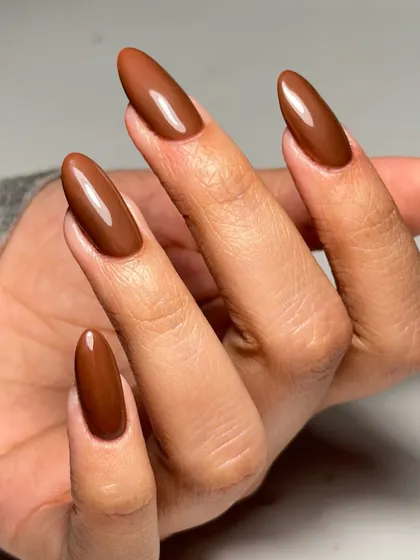 Mastering different materials is crucial. Here, we show a flawless application of acrylic extensions, shaped into a perfect almond and finished with a rich, sun-kissed brown polish. Our courses cover both gel and acrylic systems.