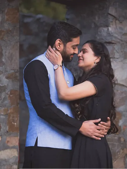 An intimate pre-wedding portrait framed by a rustic stone doorway. Their gentle embrace and loving expressions tell a story of deep connection.