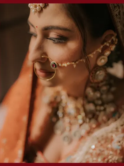 A delicate and intimate close-up of the bride Muskan, focusing on her beautiful eyes and traditional nath.