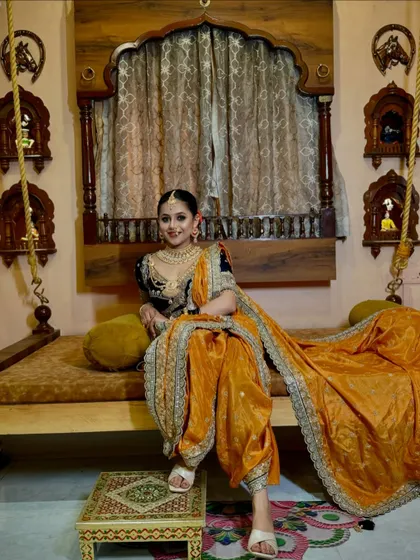 A full-length view of the orange and blue Nauvari, showing the perfect fall of the pleats and the long, elegant pallu.