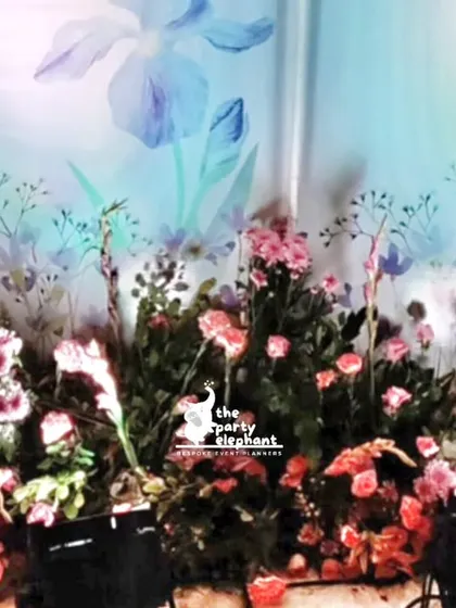 The base of our custom backdrop is adorned with a lush bed of fresh flowers, adding a natural and beautiful element to the whimsical fairy garden theme.