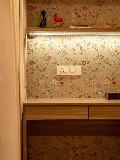 A close-up of a study area for a child's room. The floral wallpaper adds a soft, whimsical touch, creating a pleasant and inspiring nook for homework and creative pursuits.