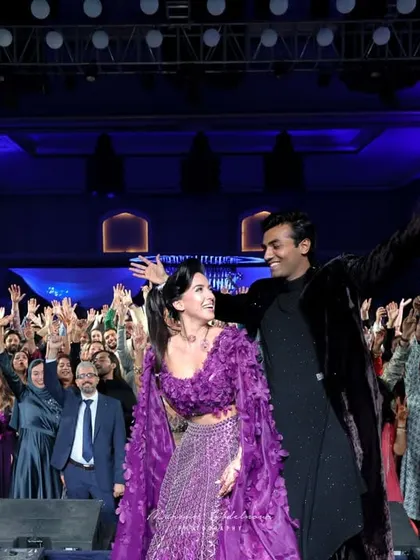 The couple on stage with the crowd fully engaged behind them. I design events that break the barrier between the stage and the audience, creating a unified, electrifying party.