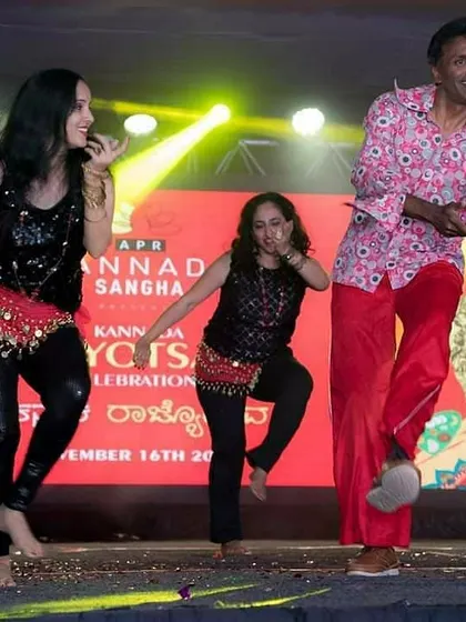 Adults of all ages enjoying themselves on stage during the Rajyotsava event. My belief is that anyone can dance, and I design my choreography to be accessible and fun for everyone.