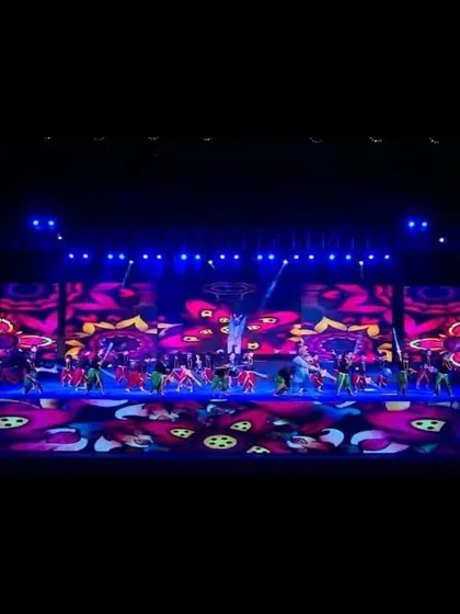 I coordinate vibrant entertainment for corporate events, like this large-scale dance performance. The stage is brought to life with dynamic LED backdrops and professional stage lighting, creating a memorable experience for all attendees.