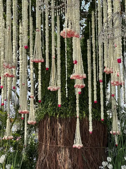 The intricate weaving of fresh flowers around the trunk of the tree, seamlessly blending our decor with nature.