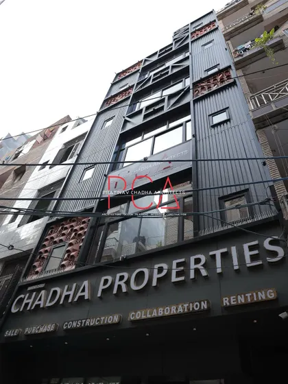 A low-angle day shot of the Chadha Properties office facade, providing a clear view of the material combination and structural design.