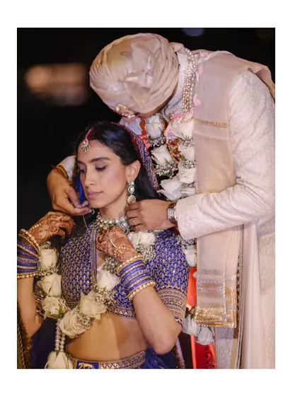 A tender moment as the groom helps the bride with her necklace. These quiet acts of love and care are the threads that weave the beautiful tapestry of a wedding day.