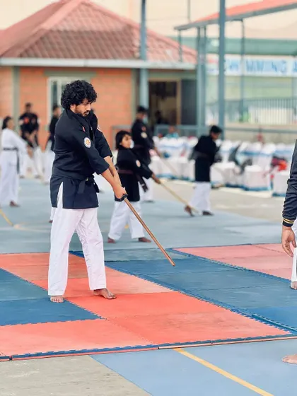 A participant practices his form, with our swimming academy visible in the background, showing our multi-sport environment.