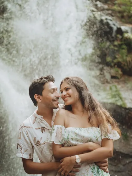 A close-up pre-wedding portrait by the waterfall, capturing the couple's happy and loving expressions.