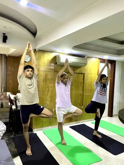 The focus and stability required for Tree Pose, demonstrated by employees during a workplace yoga session. This simple pose has great benefits for concentration.