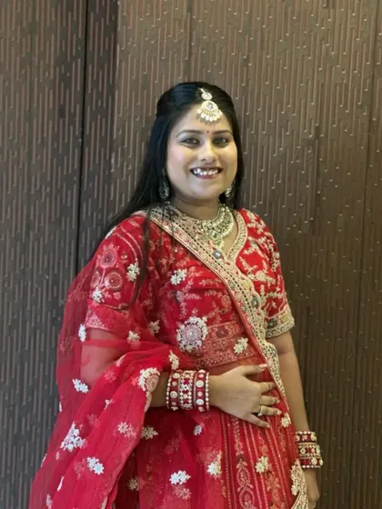 A close-up look at the blouse and dupatta of this traditional red bridal lehenga. The heavy embroidery and matching jewellery set create a complete and royal look.
