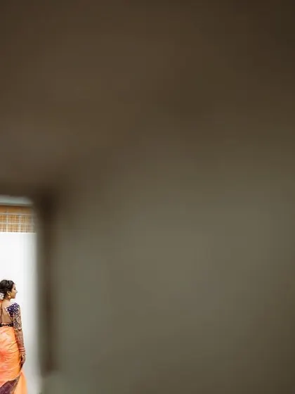 A creative shot of a couple holding hands, seen through a gap in a wall. This unique perspective adds an element of intimacy and artistry to the portrait.