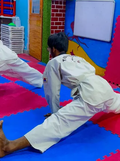 Flexibility is key in Taekwondo. A student demonstrates a full split during a conditioning session.